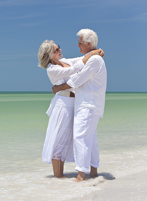 Older couple embracing at the beach