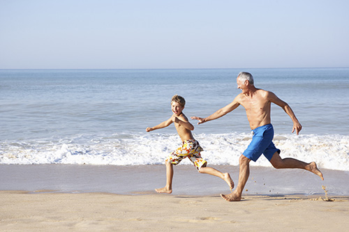 Grandfather and Grandson Running on the Beach